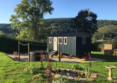 Shepherd's hut nestling in a private garden with valley views